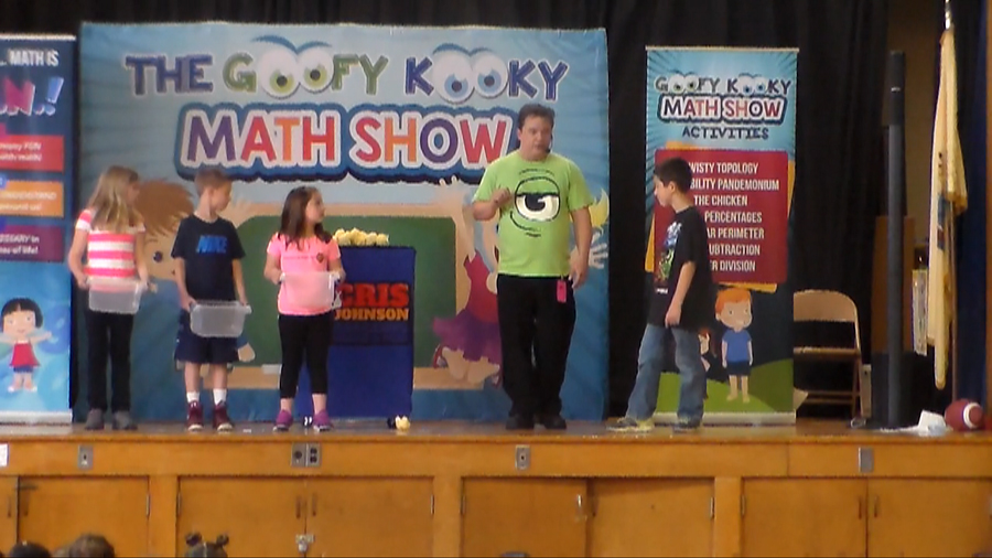 Math school assembly performer Cris Johnson with 4 volunteers