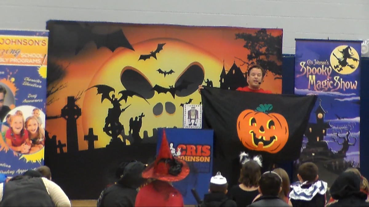 School assembly presenter Cris Jonson performing at a Halloween magic show