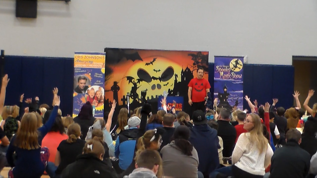 School assembly presenter Cris Jonson performing at a Halloween magic show