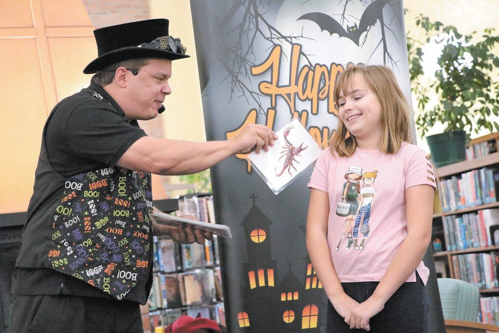 School Assembly Presenter Cris Johnson performing a Halloween trick with a volunteer